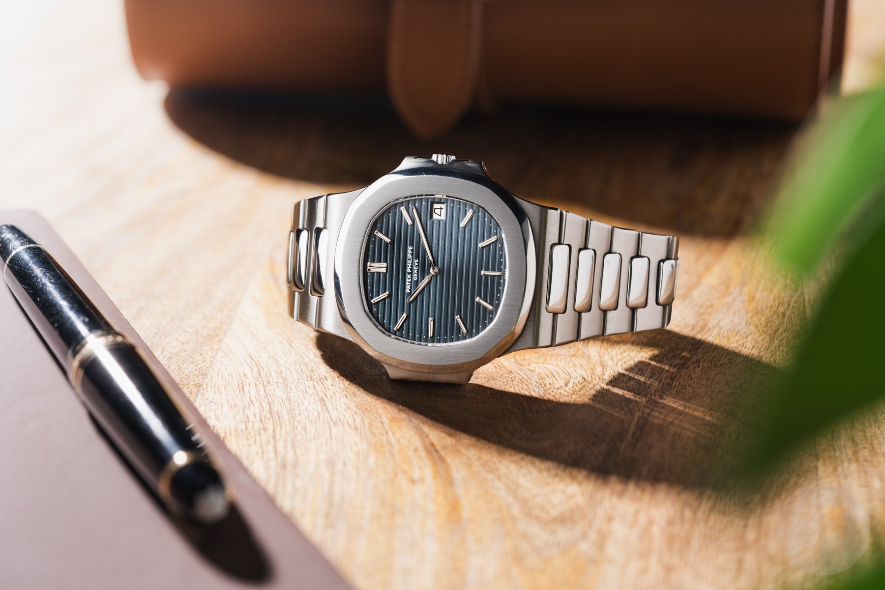 Patek Philippe Nautilus on wooden table, crown up